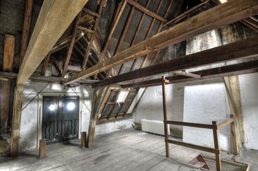 <p>Overzicht van de kapconstructie van het voorhuis, in de richting van de voorgevel. Waarschijnlijk vond in de tweede helft van de 17e-, of in het begin van de 18e eeuw nieuwbouw van het voorhuis plaats. De hijsvoorziening is later tot stand gekomen. </p>
